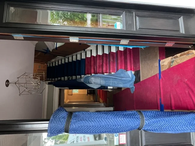 Staircase protected with moving blankets and floor runners