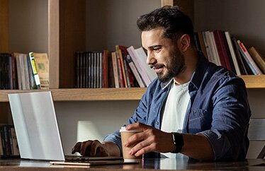 A homeowner reviews insurance discounts on their computer in their home office.