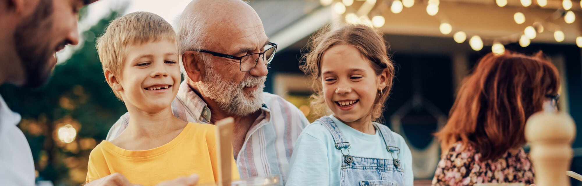 A grandfather and his two grandchildren at home.