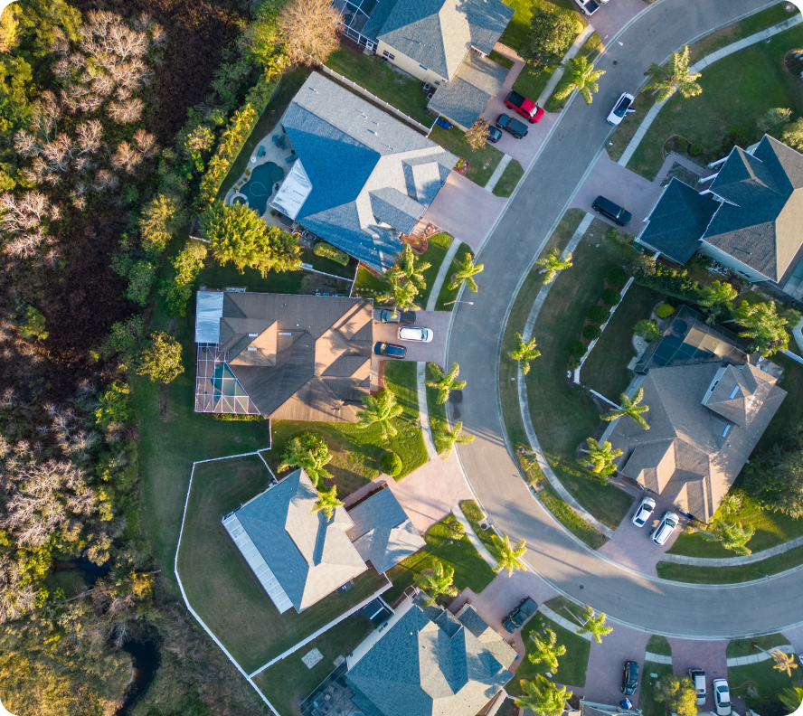 An aerial view of a residential neighborhood, showing houses, streets, and trees from above.