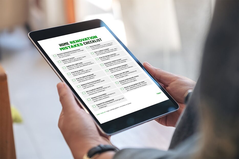 A homeowner reviews their home renovation mistakes checklist on a tablet.