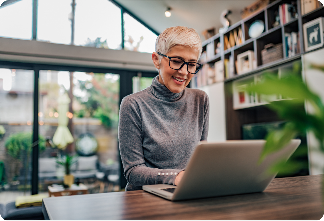 A smiling woman on a laptop.