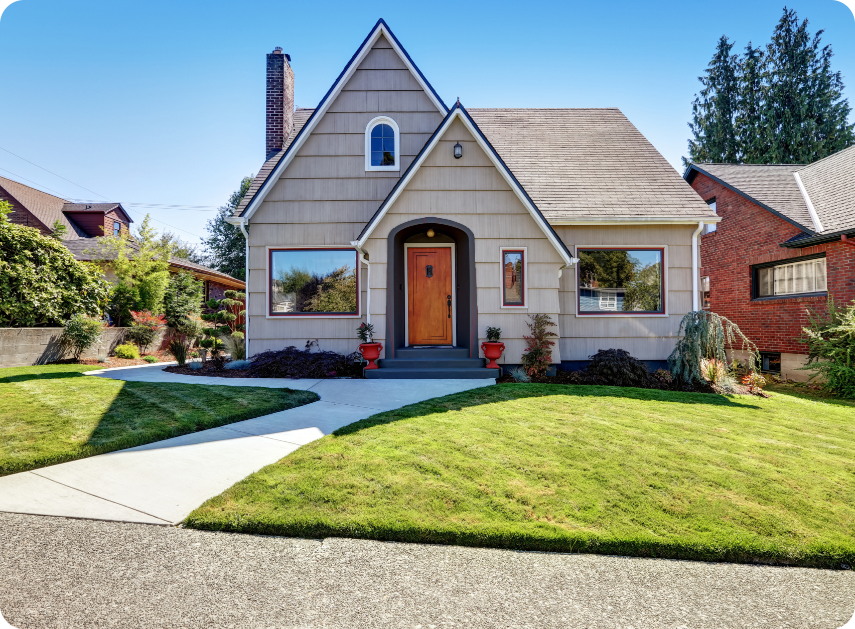 A well-maintained single-story home with a manicured lawn and clear blue sky.