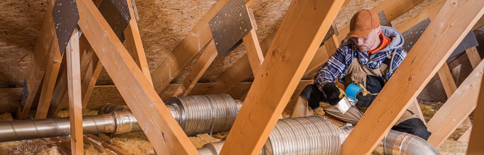 Homeowner repairs ventilation system during the winter season.