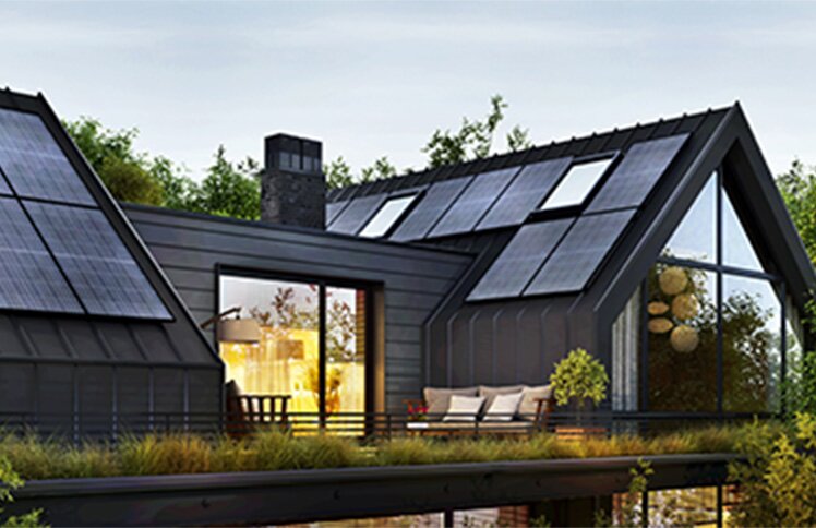 A modern, disaster-resilient home features prominent solar panels integrated into its dark metal roof. Large windows and a brick facade are also visible.