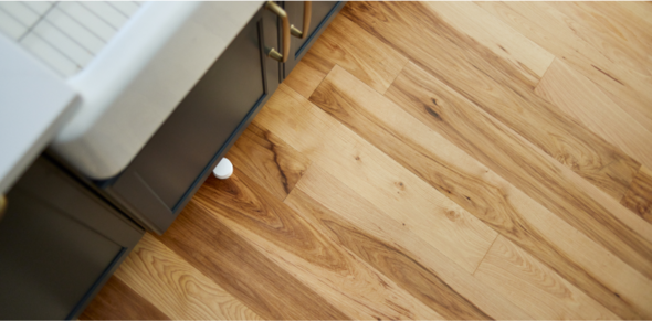 A small water leak sensor lying on the kitchen floor