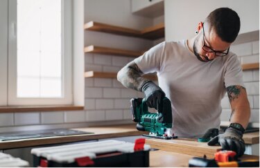 A homeowner works on home improvements in a kitchen.