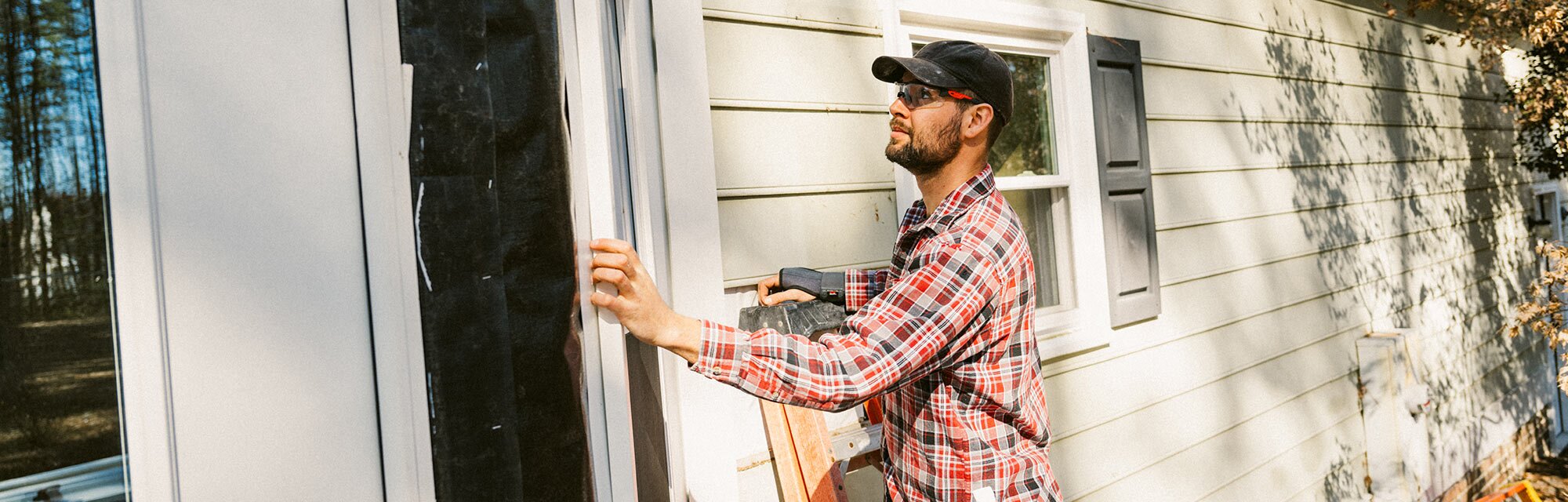  A man repairs the outside wall of his house.