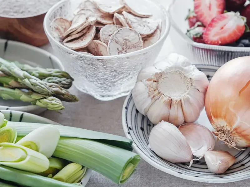 Bowls of mushrooms, onions, strawberries, and asparagus