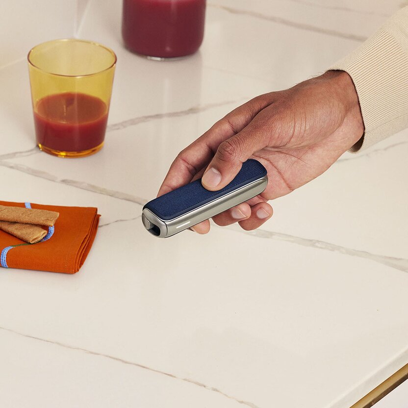hand-holding-Ploom-AURA-with-navy-blue-cover