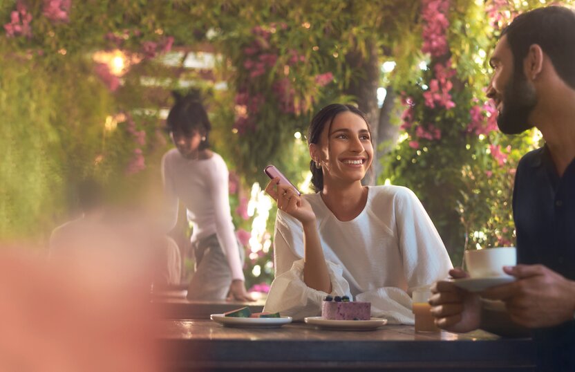 woman-holding-purple-device-at-cafe