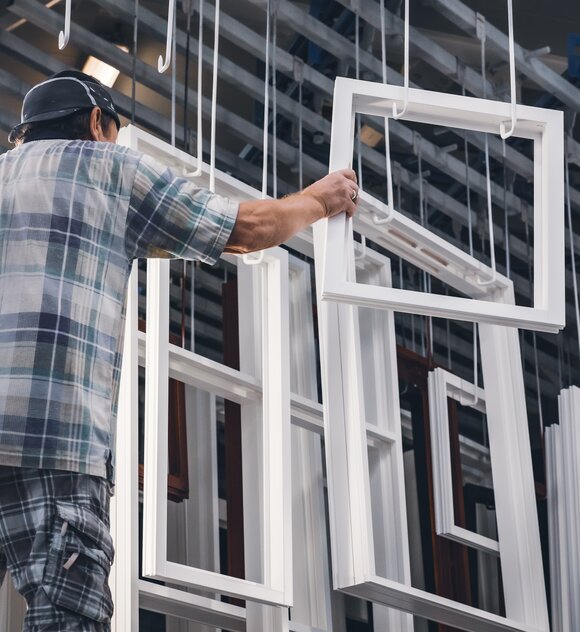 Sparkozijnen - nieuw geproduceerde witte ramen hangend aan plafond in raamfabriek