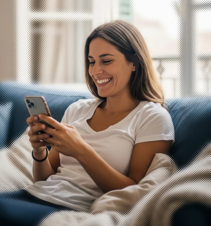 Image of a woman looking at her phone on a sofa