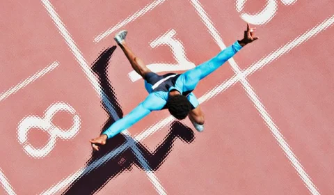 Birds eye view of man running over a finishing line