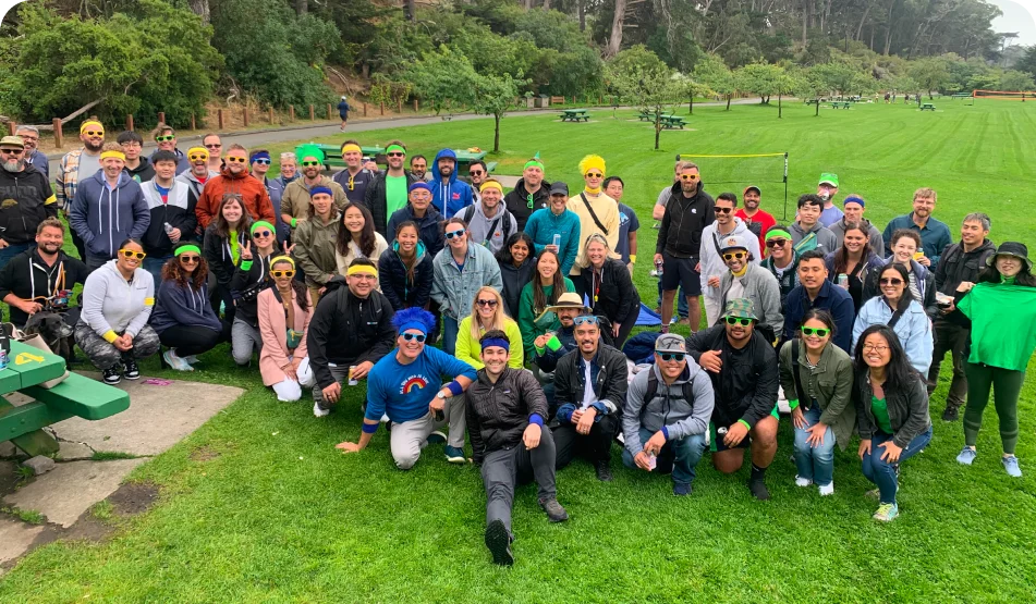Quantcast team members wearing colored headbands pose in a field during a team outing.