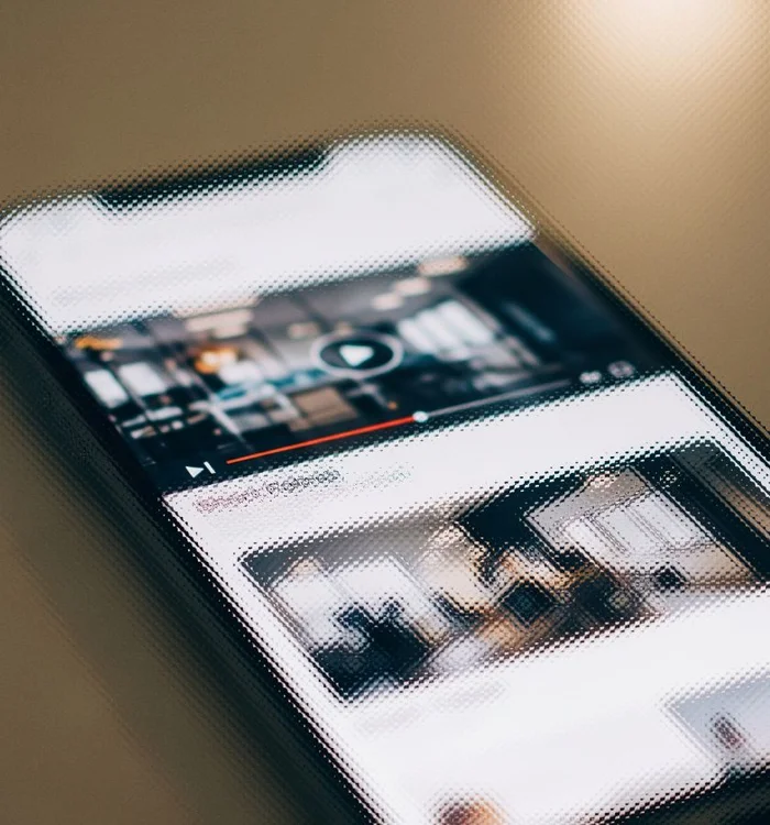 Image of a smartphone with an out of focus video player on screen