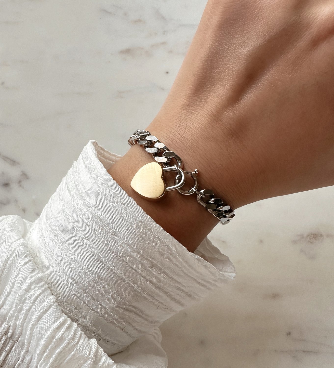Women's wrist with MVMT heartlock bracelet