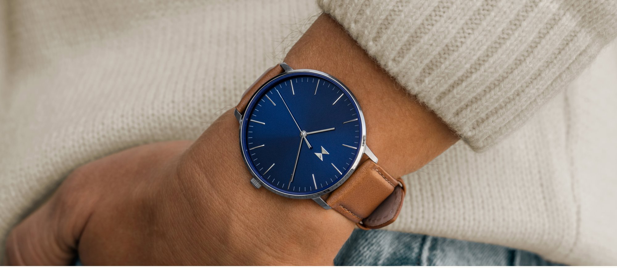 MVMT Legacy Slim watch with tan strap and blue face on wrist