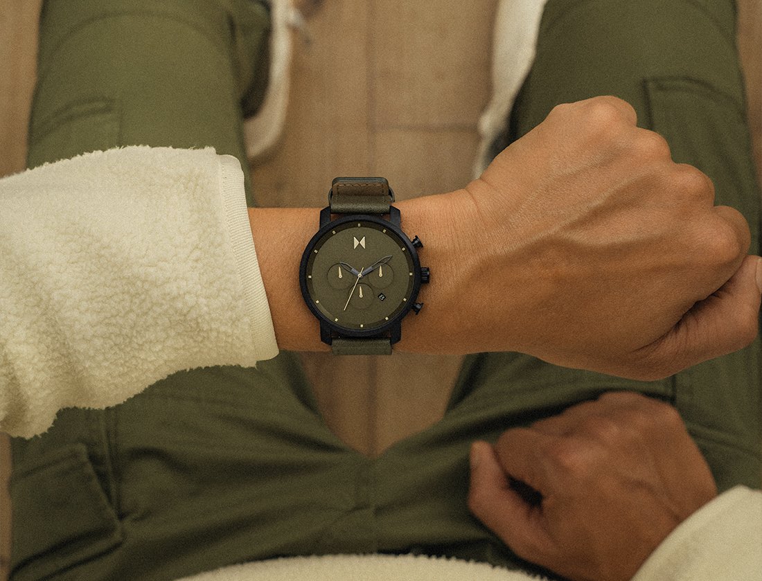 MVMT green Blacktop watch w green strap on male model's wrist