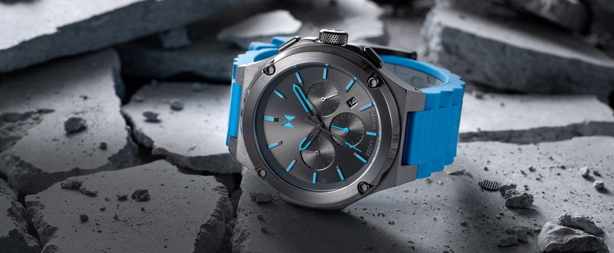 MVMT watch with blue strap and black face lying on cracked concrete