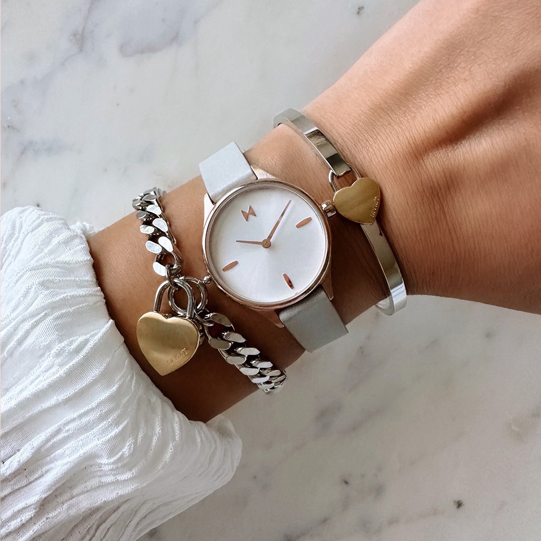 MVMT Grey leather Reina watch with two silver bracelets on wrist