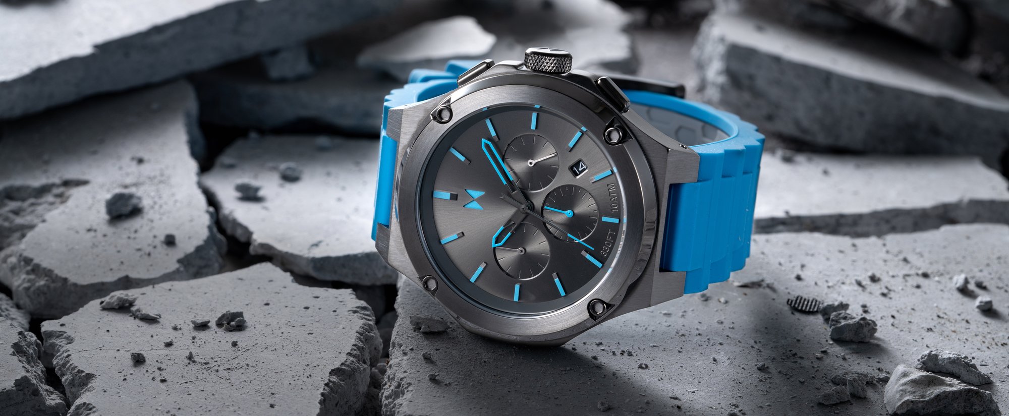 MVMT watch with blue strap and black face lying on cracked concrete