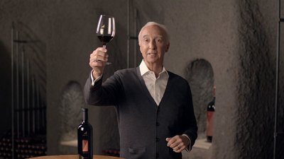 Justin Baldwin holding a glass of red wine 