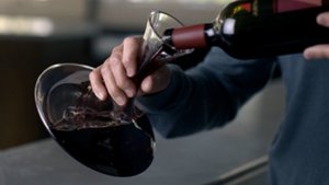 wine being poured into a decanter 