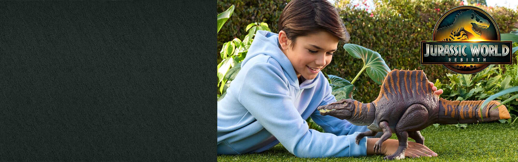 A child plays with a dinosaur toy on grass.