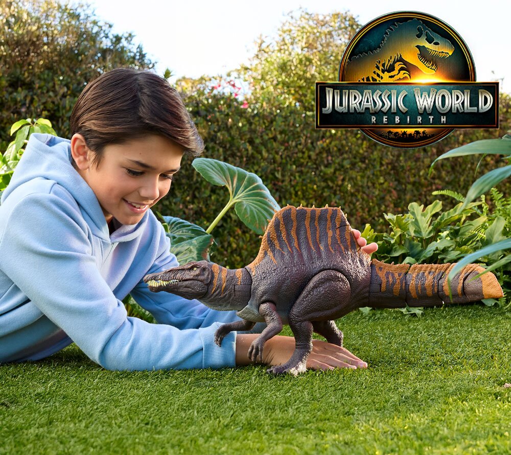 A boy playing with a dinosaur on the grass.
