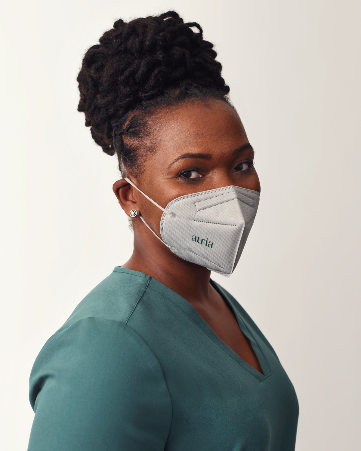 HeadshotHeadshot of an Atria healthcare worker in teal scrubs and a branded mask with a white background of a healthcare worker in teal scrubs and a branded mask with a white background