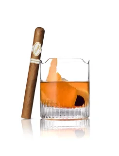 Bourbon Pie cocktail with orange twist and cherry beside a Davidoff Aniversario Double R cigar.