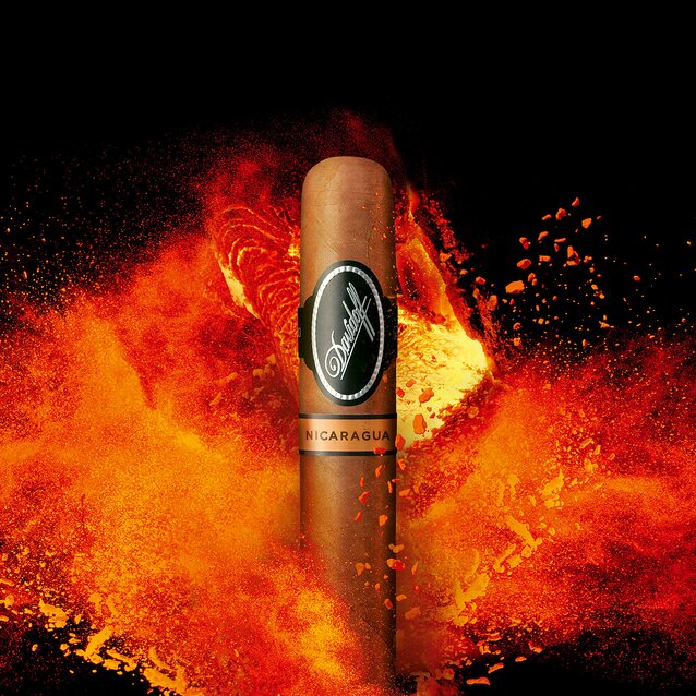 A Davidoff Nicaragua cigar standing in front of a powerful bright orange fire.