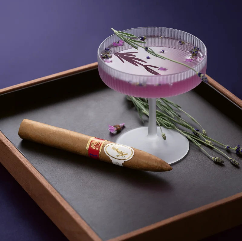 The Year of the Sheep piramides cigar next to a Purple Gin Cocktail.