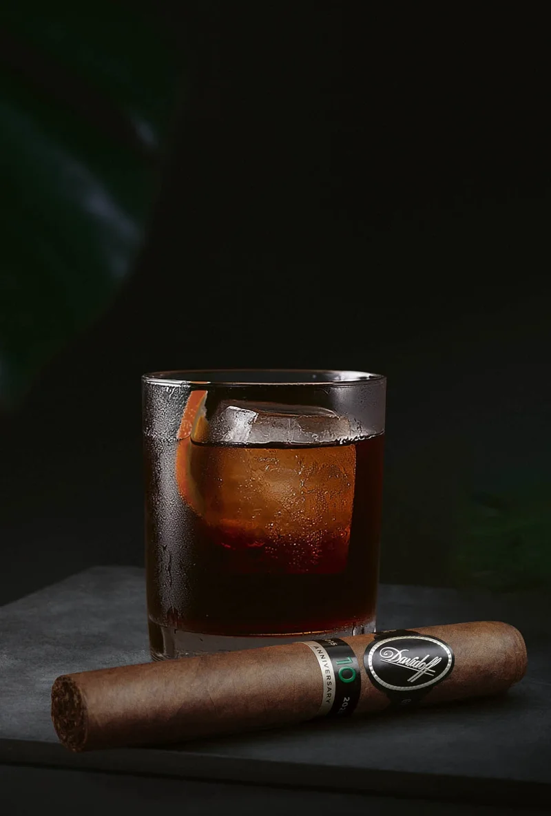 A Davidoff Escurio 10th Anniversary cigar in front of a glass of Cold Fashioned. 