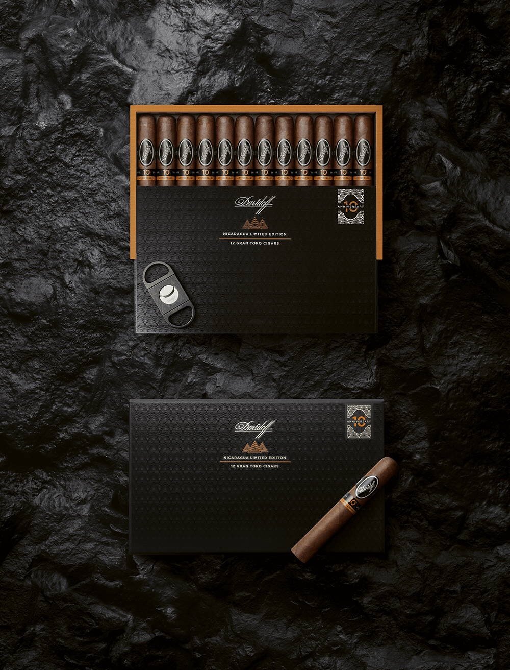 The Davidoff Nicaragua 10th Anniversary Limited Edition gran toro cigar in its opened box with the Davidoff Nicaragua Double Blade Cutter placed on top of it.