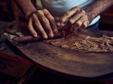 Hands rolling a Davidoff cigar.