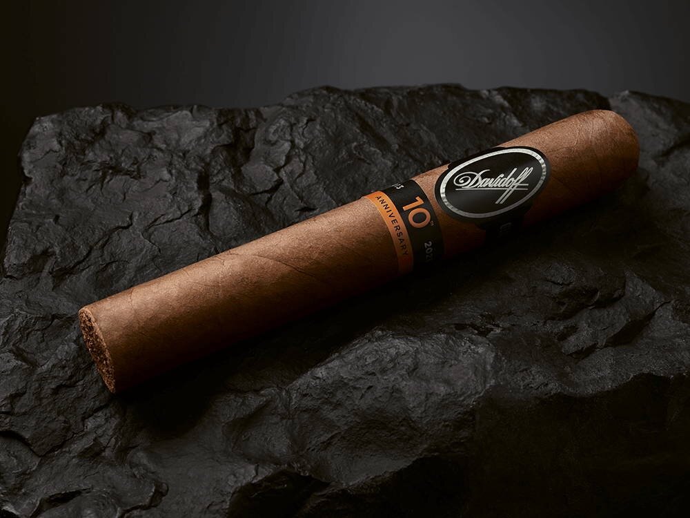 The Davidoff Nicaragua 10th Anniversary Limited Edition gran toro cigar lying on top of a black rock.