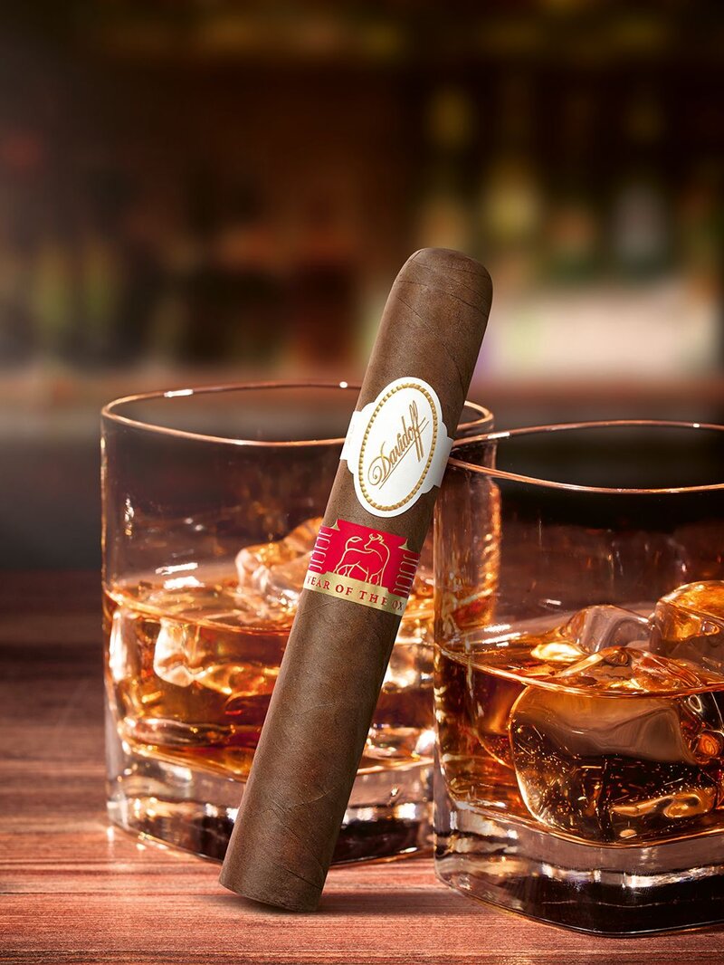 The Davidoff Year of the Ox Limited Edition cigar leaning against one of two glasses filled with cognac.