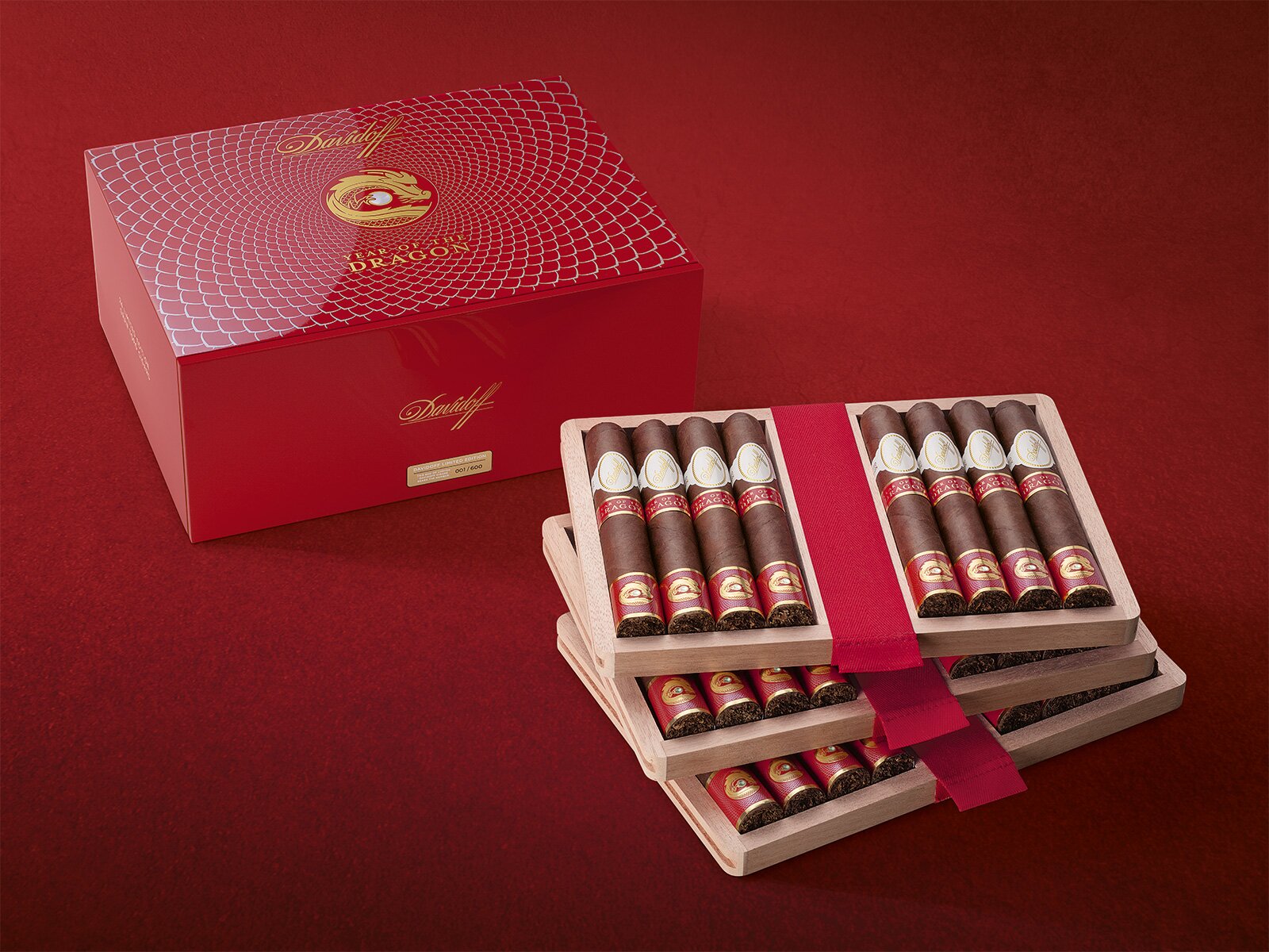 Two Davidoff Year of the Dragon Limited Edition Gran Toro cigars placed on the lid of their box.