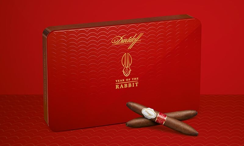 A close-up of the Davidoff Year of the Rabbit Limited Edition cigar box with a pyramid cigars crossed next to it.