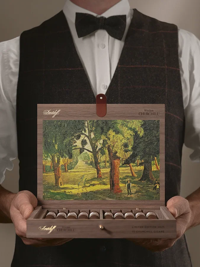 Man holding the opened box of the Limited Edition 2025 showing Churchill's painting on the inside of the lid.