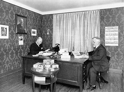 George Huppuch and another businessman sitting across each other in an office room