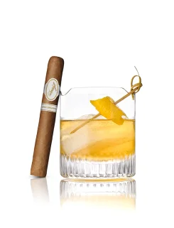 Davidoff Aniversario No. 3 cigar beside a citrus cocktail with ice and lemon twist.
