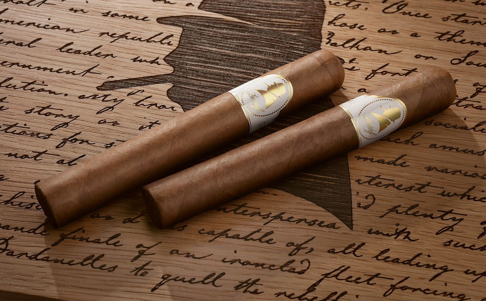 Two Winston Churchill «The Original Series» cigars on top of the bright Raconteur Primos Humidor