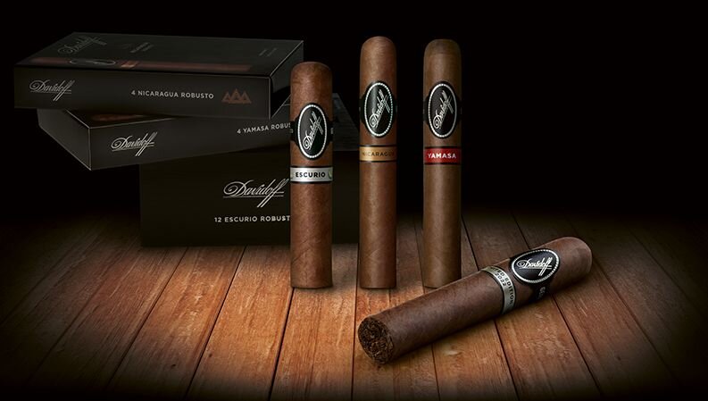 Black Band cigars Nicaragua, Yamasa and Escurio on top of each other on a wooden floor.