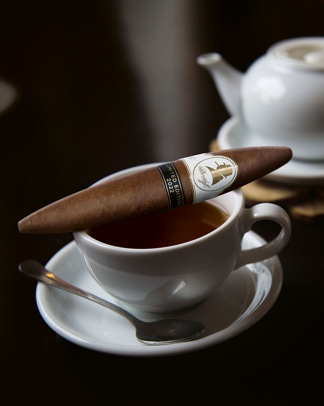 Teacup with Davidoff Winston Churchill Limited Edition 2022 perfecto cigar resting on top. 