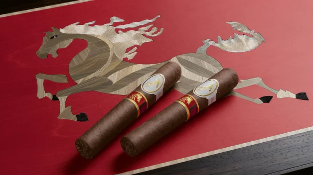 Two Davidoff Year of the Horse cigars rest on a vibrant red surface, featuring an intricate wood inlay of a galloping horse. Elegant and artistic design.