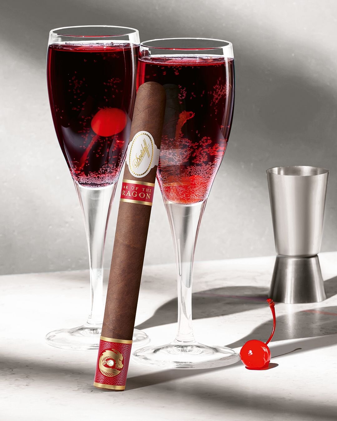 The Davidoff Year of the Dragon Limited Edition cigar leaning against one of two glasses filled with Kir Royale cocktail.