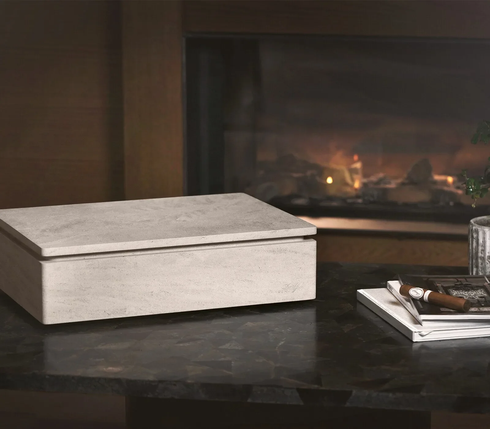 Davidoff Monolith Humidor made of stone on a table with a fireplace in the background